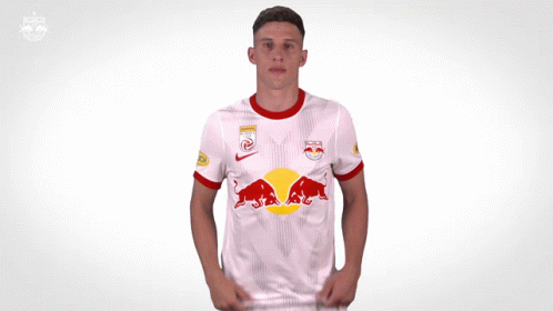 a man is wearing a white shirt with a red bull on it