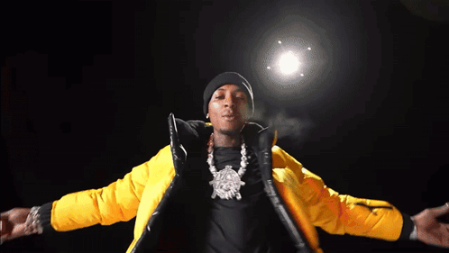 A Man Is Wearing A Yellow Jacket And A Black Beanie GIF