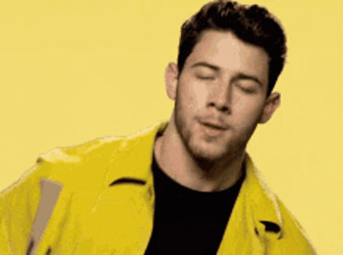 A Man Is Wearing A Yellow Jacket And A Black Shirt . GIF