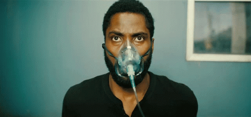 A Man Is Wearing An Oxygen Mask On His Face GIF