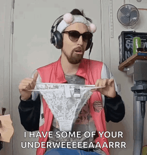 A Man Is Wearing Headphones And Holding A Pair Of Underwear . GIF