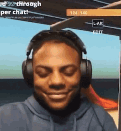 A Man Is Wearing Headphones And Smiling While Playing A Video Game . GIF