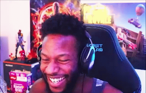 A Man Is Wearing Headphones And Smiling While Sitting In A Chair . GIF
