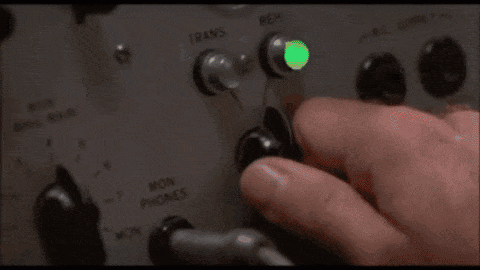 A Man Is Wearing Headphones And Talking Into A Microphone . GIF