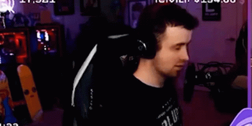 A Man Is Wearing Headphones While Sitting In A Chair . GIF