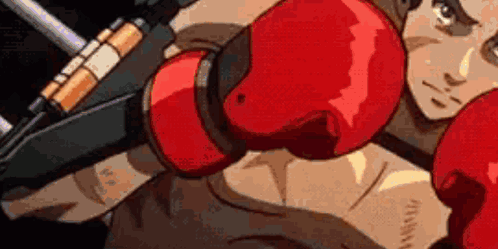 A Man Is Wearing Red Boxing Gloves And Holding A Gun In His Hand . GIF