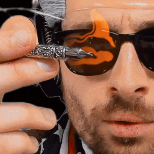 A Man Is Wearing Sunglasses And Holding A Pen GIF