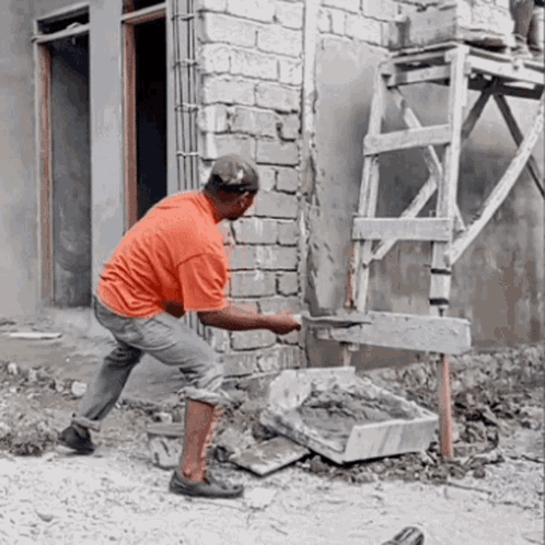 A Man Is Working On A Brick Wall With A Shovel GIF