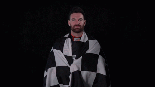 A Man Is Wrapped In A Black And White Checkered Cloth GIF
