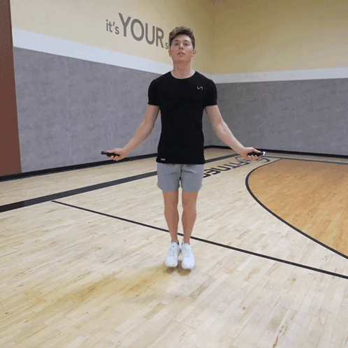 A Man Jumping A Jump Rope In Front Of A Wall That Says " It 'S Your " GIF