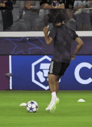 A Man Kicks A Soccer Ball In Front Of A Sign That Says Fc GIF