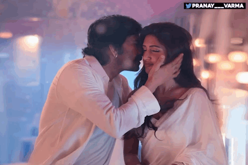 A Man Kisses A Woman On The Forehead With A Pranay_varma Logo In The Corner GIF