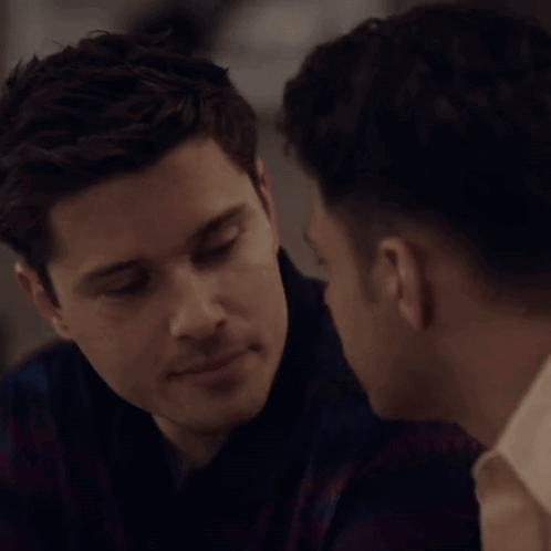 A Man Kissing Another Man On The Cheek In A Close Up GIF