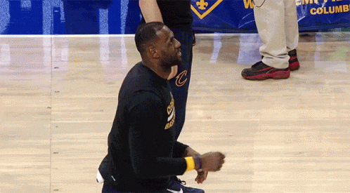 A Man Kneeling On A Basketball Court Wearing A Black Shirt With The Letter C On It GIF
