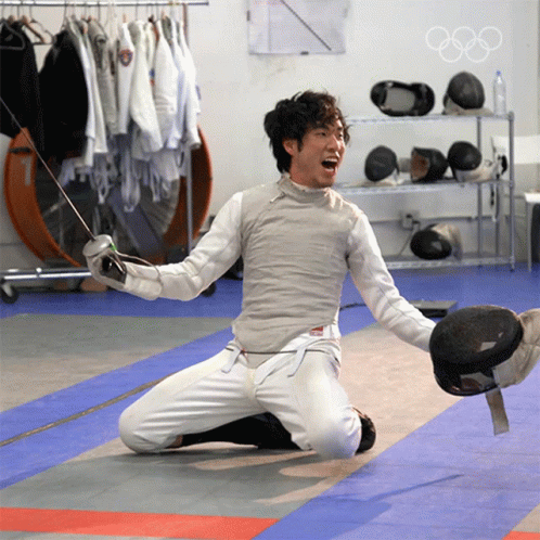 A Man Kneeling On The Floor With A Sword In His Hand GIF