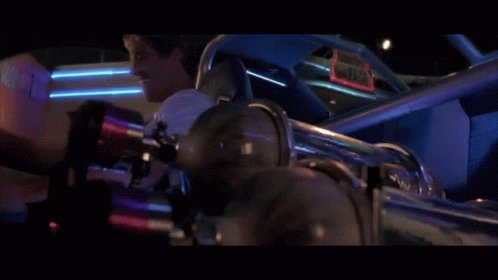 A Man Laughs While Sitting In A Car With A Sign That Says Gator GIF