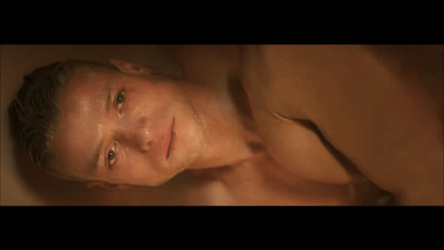 A Man Laying Down With His Hand On His Forehead GIF