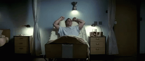 A Man Laying In A Hospital Bed With His Arms Outstretched GIF