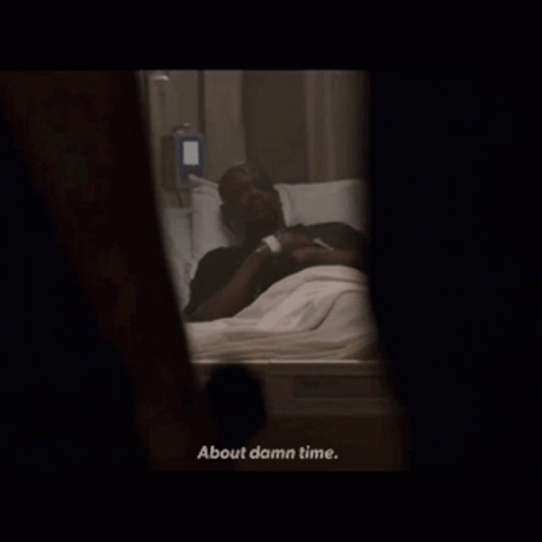 A Man Laying In A Hospital Bed With The Words About Damn Time Below Him GIF
