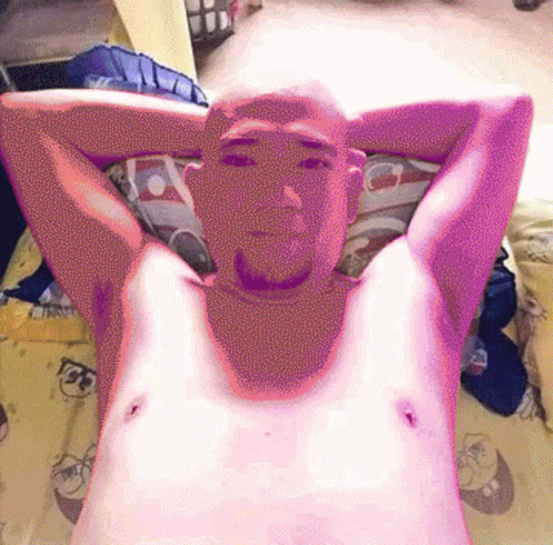 A Man Laying On A Bed With His Arms Behind His Head GIF