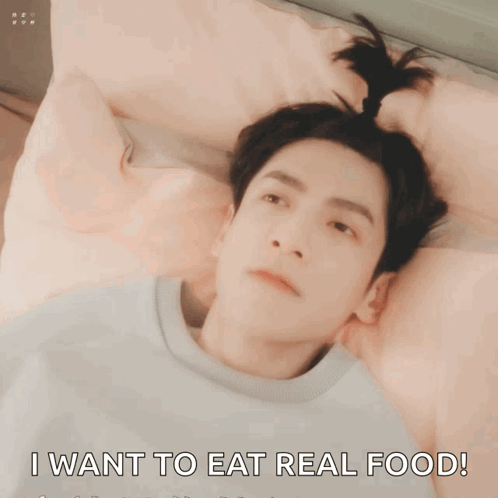 A Man Laying On A Bed With His Mouth Open And The Words I Want To Eat Real Food GIF