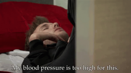A Man Laying On A Bed With The Words " My Blood Pressure Is Too High For This " Next To Him GIF