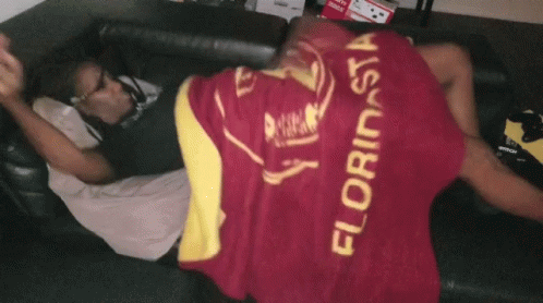 a man laying on a couch with a blanket that says florinsia