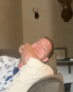 A Man Laying On A Couch With His Head On Another Person 'S Lap GIF