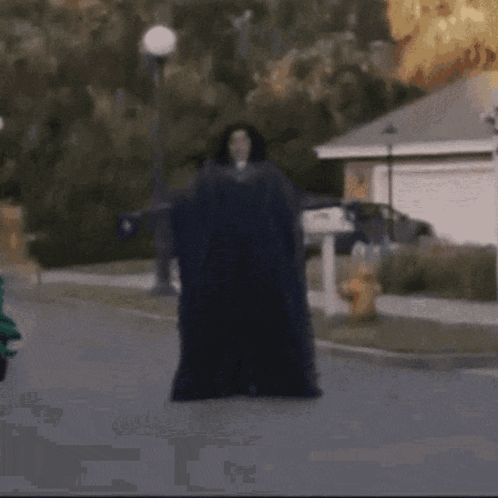 A Man Laying On The Ground In Front Of A House GIF
