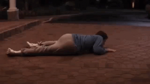 A Man Laying On The Ground In Front Of A White Car With The Word End Written On The Bottom GIF