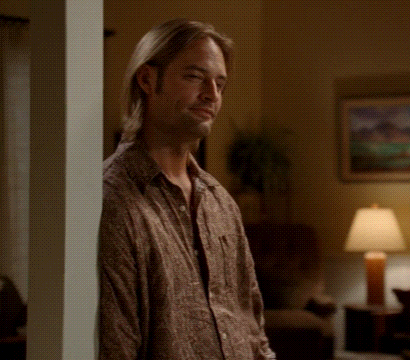 A Man Leaning Against A Wall In A Living Room GIF
