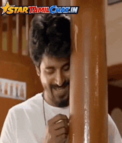 A Man Leaning Against A Wooden Pole With The Words Star Tamilchat.in Written Above Him GIF