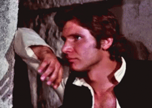 A Man Leaning On A Wall With His Hand On His Chin GIF