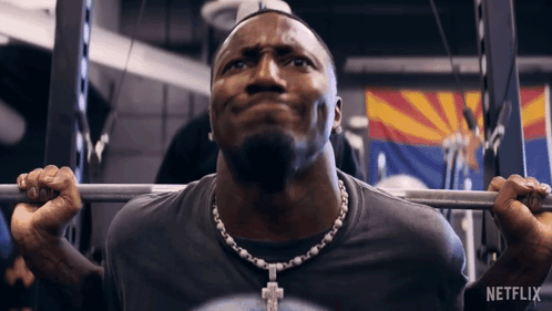 A Man Lifting A Barbell In A Gym With Netflix Written On The Bottom GIF