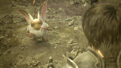A Man Looking At A Small Creature With A Face GIF