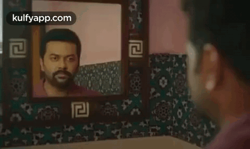 A Man Looking At His Reflection In A Mirror . GIF