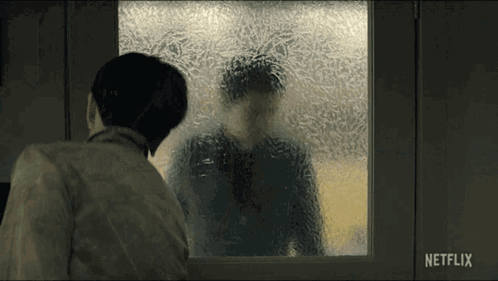 A Man Looking Out A Window With A Netflix Logo On The Bottom Right GIF