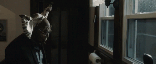 A Man Looking Out A Window With A Paper Towel Hanging On The Wall GIF