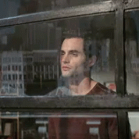 A Man Looking Out A Window With A Reflection Of A Building GIF