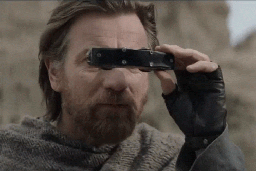 A Man Looking Through A Pair Of Binoculars With A Beard GIF