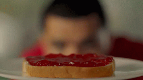 A Man Looks At A Slice Of Peanut Butter And Jelly Toast GIF