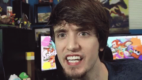 A Man Making A Funny Face In Front Of A Screen That Says Splat GIF