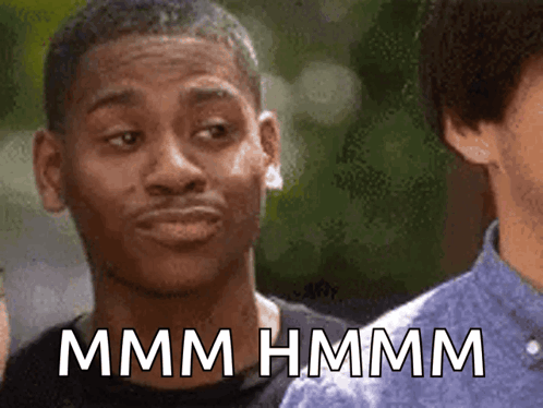 a man making a funny face with the words mmmm hmmm written below him