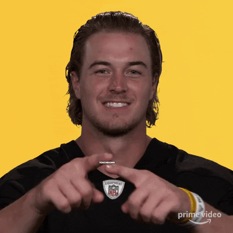 A Man Making A Heart Shape With His Hands In Front Of A Yellow Background GIF
