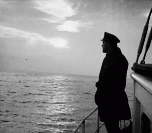 A Man On A Boat Looking Out Over The Ocean GIF