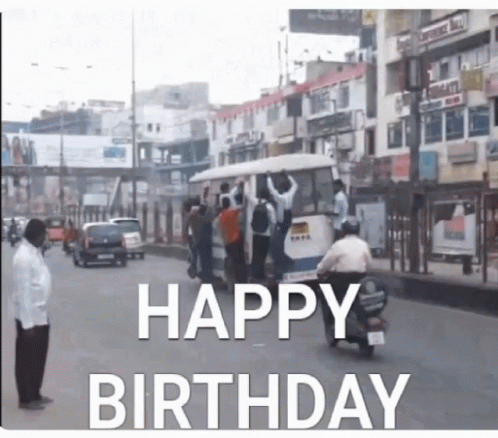 A Man On A Motorcycle Is Driving Down A Street With The Words Happy Birthday Written On It GIF