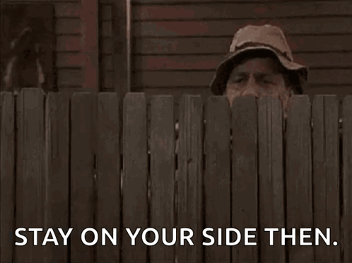 A Man Peeking Over A Wooden Fence With The Words Stay On Your Side Then . GIF