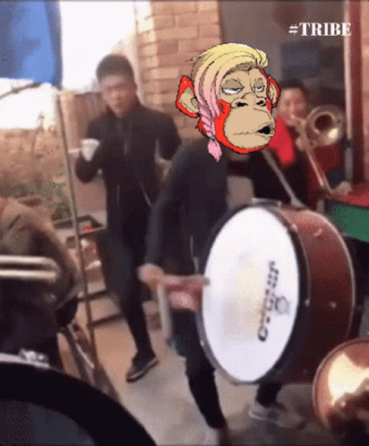A Man Playing A Drum With A Monkey On His Head And The Words #Tribe Below Him GIF