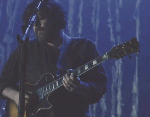 a man playing a gibson guitar on stage