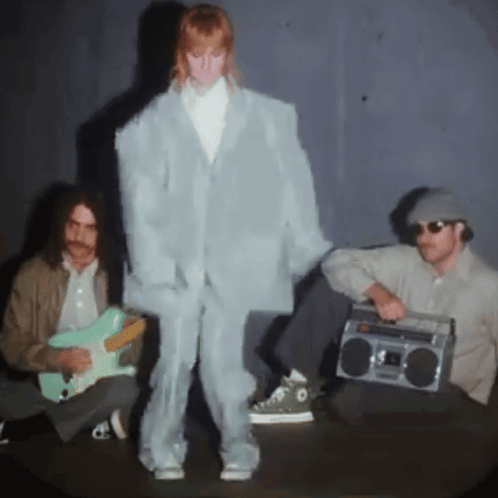 A Man Playing A Guitar And A Man Holding A Boom Box GIF